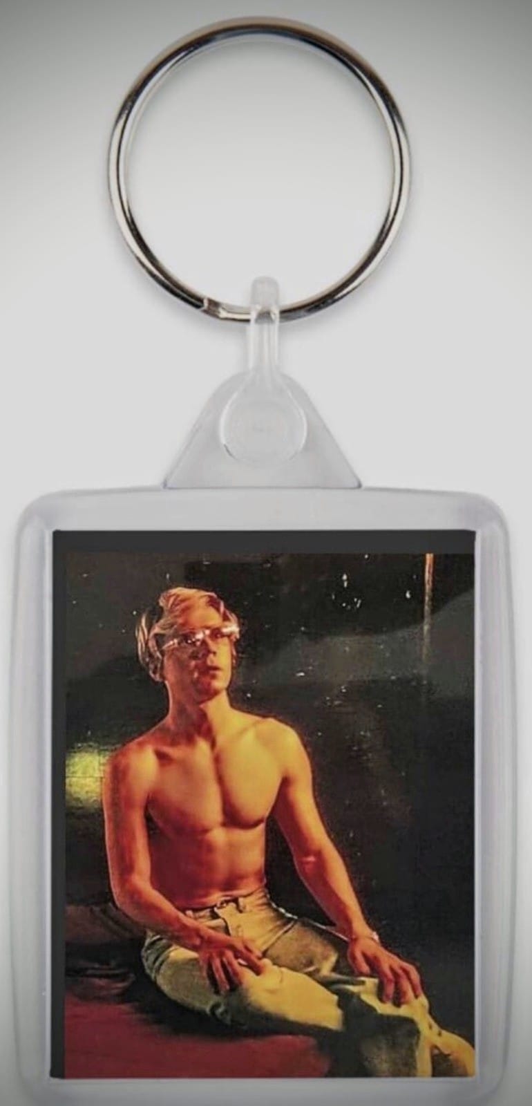 Dahmer Monster Keychain with Evan Peters sitting on the bed